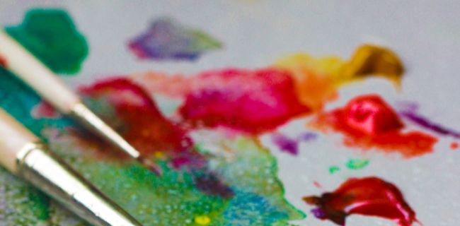 Bunte Farben, die sich vermischen und Pinsel