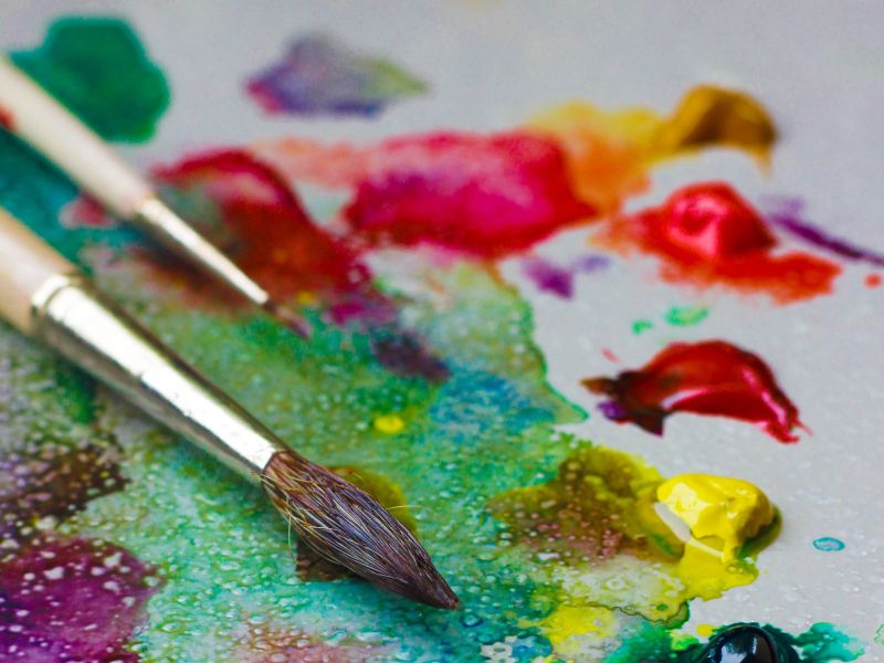 Bunte Farben, die sich vermischen und Pinsel