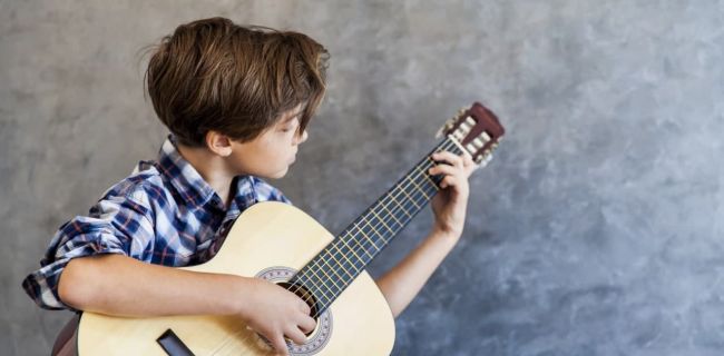 Kind spielt Gitarre